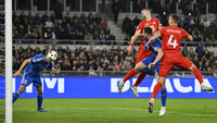 Italienischer Spieler verteidigt gegen Nordmazedonien bei einer spannenden Kopfballsituation im Strafraum.