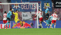 RB Leipzig-Spieler erzielt ein Tor gegen Bayer Leverkusen während eines Bundesliga-Spiels vor jubelnden Fans.