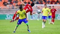 Brasilianischer Spieler im Duell mit einem iranischen Spieler während eines internationalen Fußballspiels.
