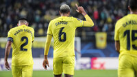 Spieler von Villarreal CF im gelben Trikot feiern auf dem Spielfeld während eines Champions-League-Spiels.